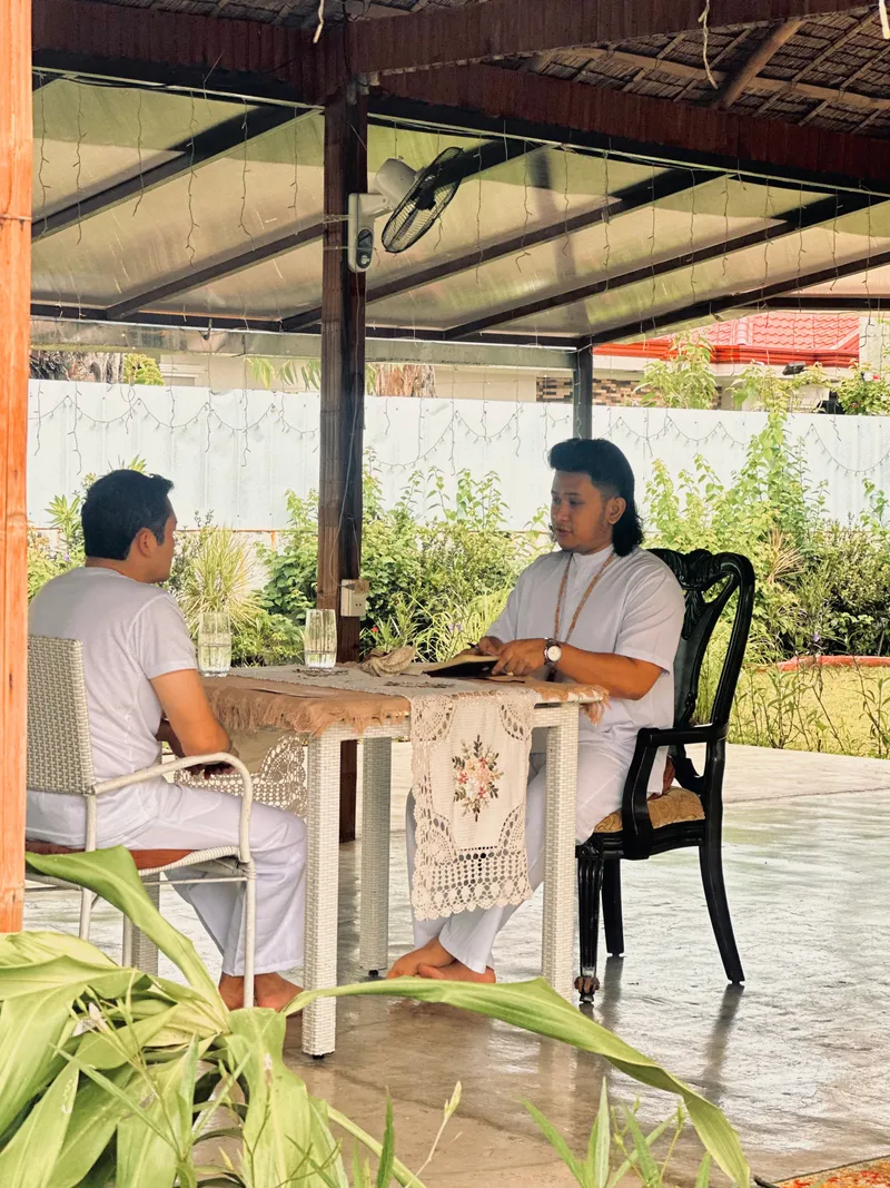 Teacher Ian and a participant in a one-on-one mindful happiness coaching conversation at a wooden table