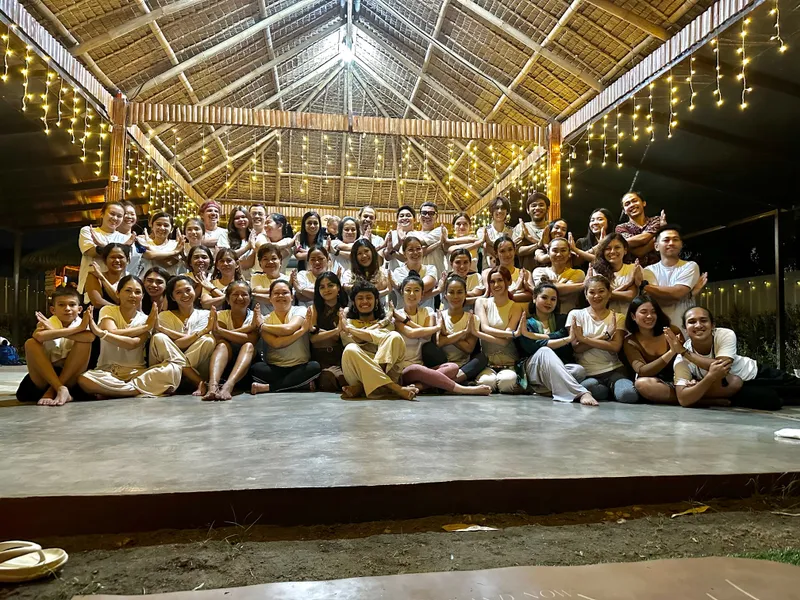 Outdoor Sunday community yoga class at Tallaro with mats spread across the garden