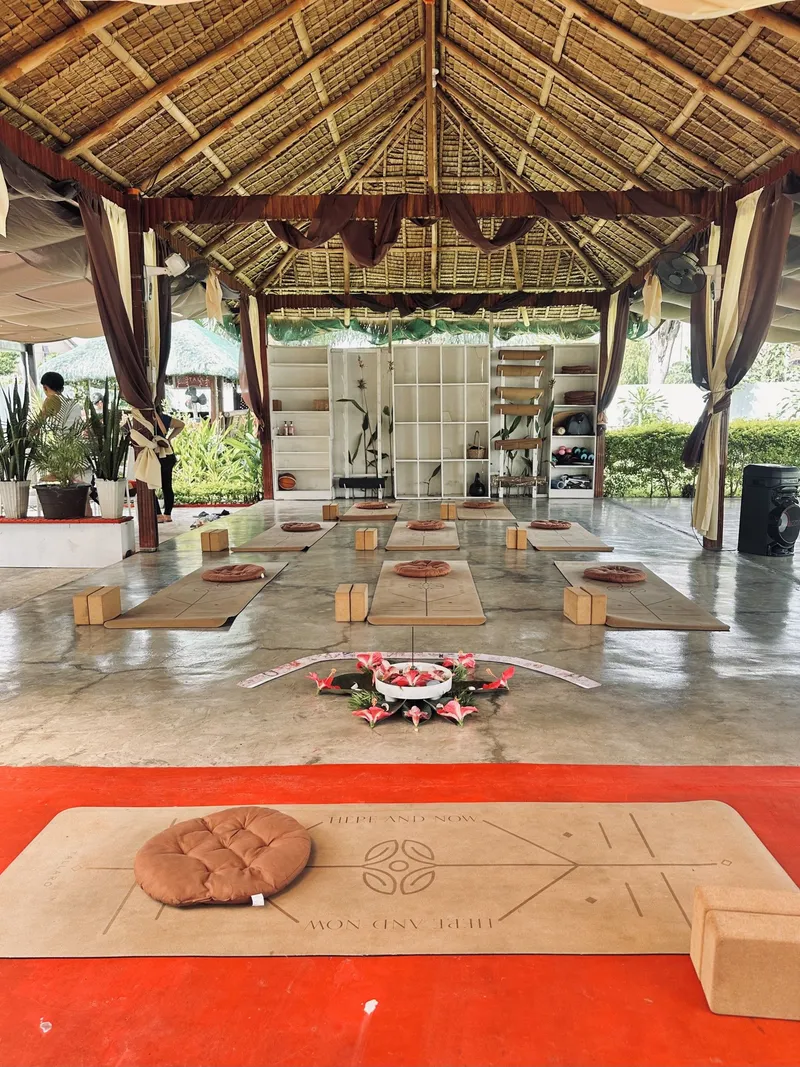 The thatched Tallaro pavilion set with mats, blocks and a flower centrepiece