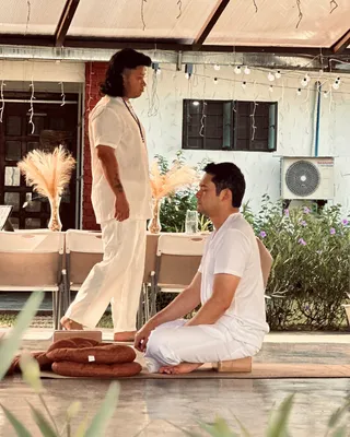 Jaime M. Singson seated in meditation on a mat during an outdoor Tallaro practice